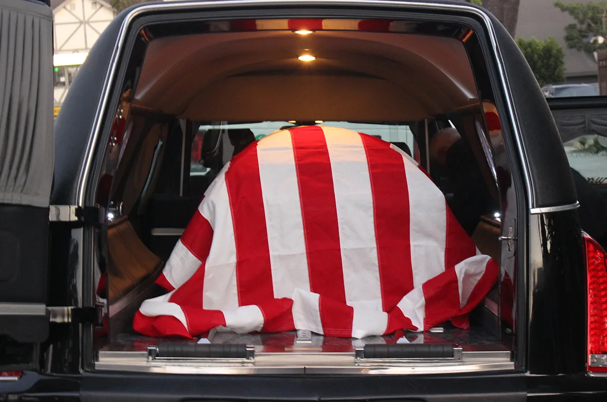 casket draped in U.S. flag inside hearse
