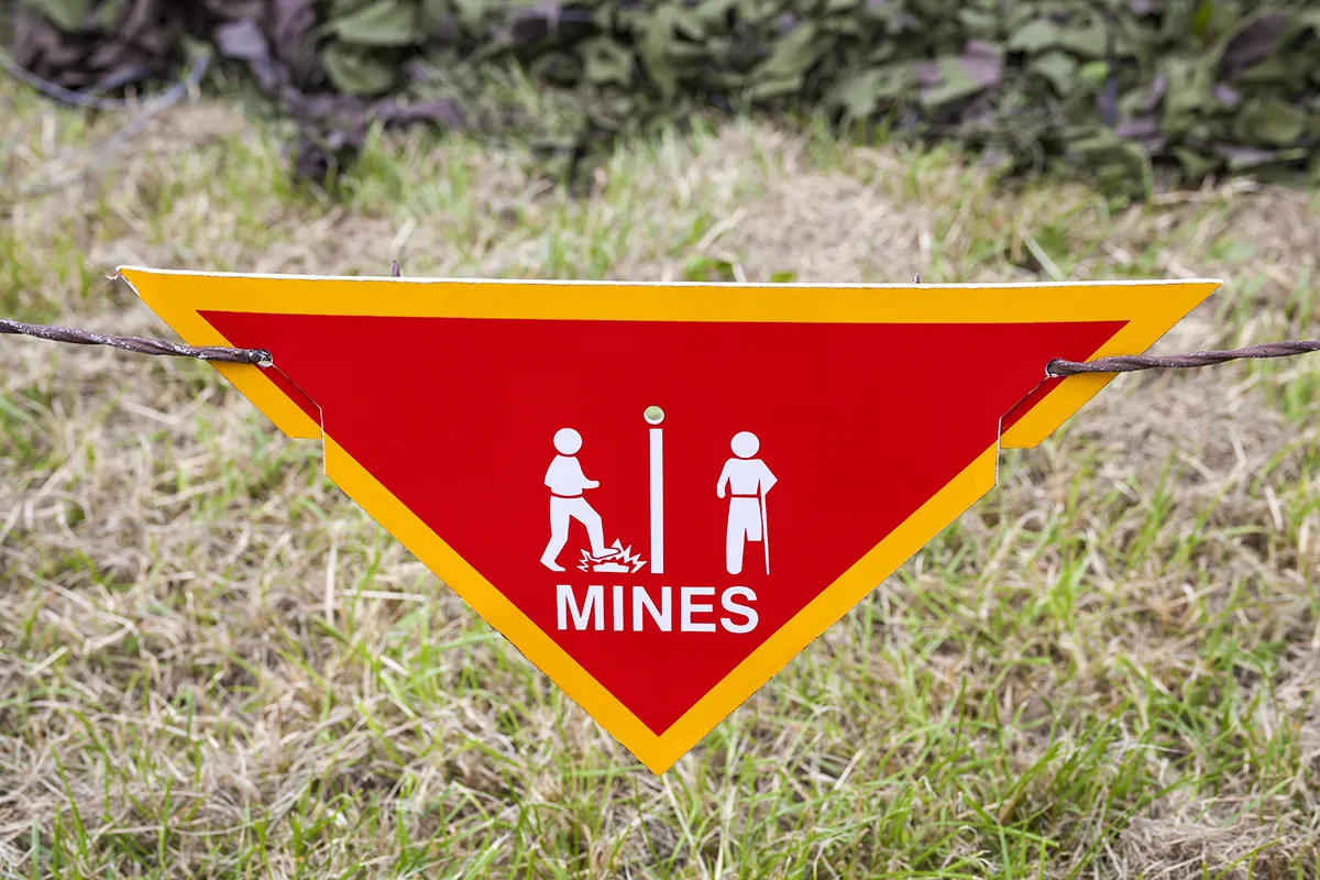 Sign with symbols of stepping on landmine and person with leg missing