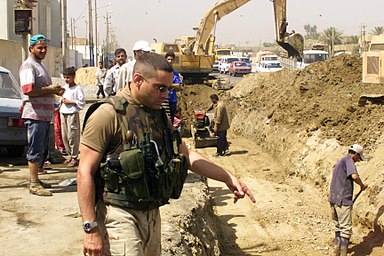 Man in desert fatigues inspecting a construction site