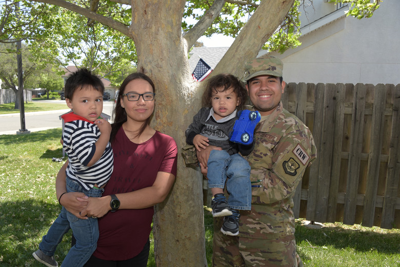 Service member posing for a picture with his family