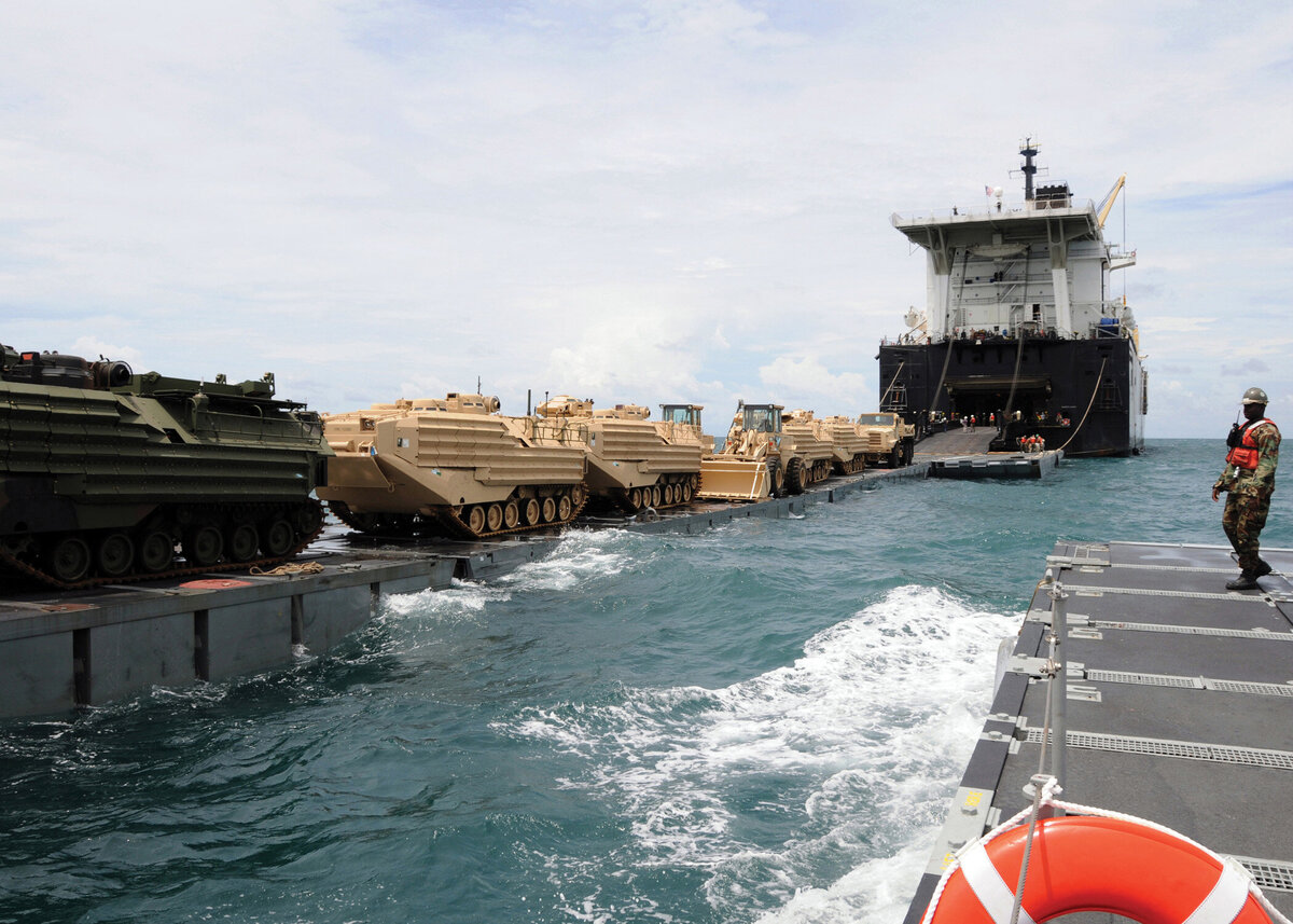 Military vehicles move ship to barge to shore in Maritime Prepositioning Force exercise