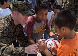 U.S. Marine Corps Civil Affairs Staff Sgt. Alan O'Donnell hands out soccer balls to children at a medical civic action project (MEDCAP) during Southern Partnership Station 2014.
