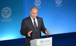 Vlad Putin giving a speech at a podium