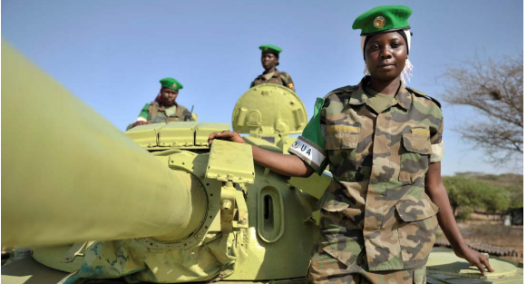 “Tank driver, Lance Corporal Mudondo Zabina, tank commander, Corporal Kyomuhendo Ballet and tank gunner Lance Corporal Otuga Maureen of the Uganda Peoples Defence Forces on their tank.