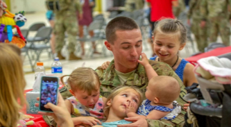A soldier holding children at a birthday party