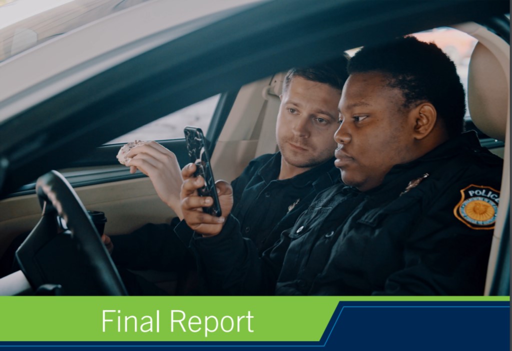 Two officer's in their vehicle looking at a cell phone