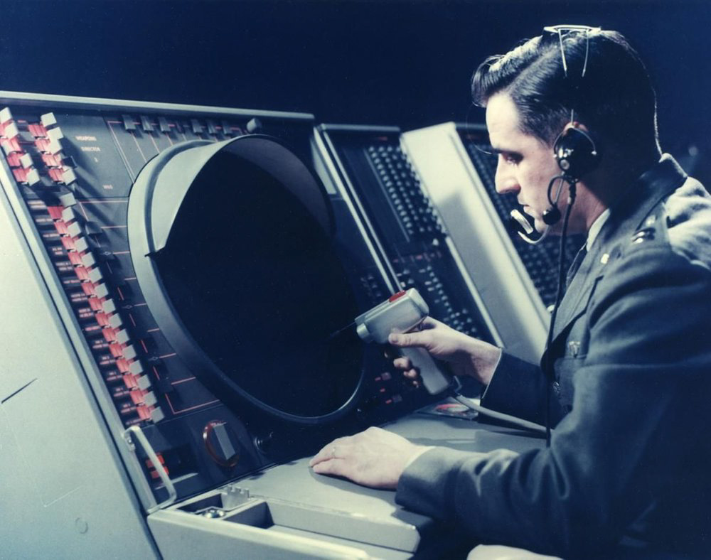 An Air Force officer operates a terminal for the Semi-Automatic Ground Environment, the world’s first networked computer system. Beginning in the late 1950s, it aggregated data from hundreds of radars to coordinate the defense of North America against nuclear-armed Soviet bombers. Photo credit: MIT Lincoln Lab.