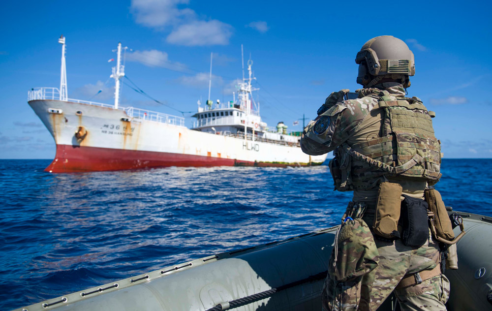 A member of US Coast Guard Law Enforcement Detachment 107 aboard guided-missile destroyer USS Shoup takes a photo of a fishing vessel during the Oceania Maritime Security Initiative program in the Western Pacific (US Navy photo).