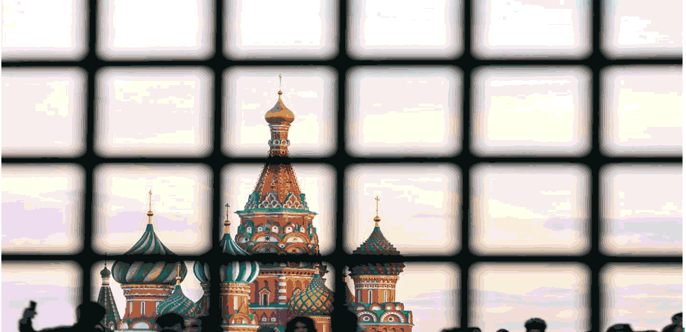 St. Basil's Cathedral on Red Square with a large number of people is hidden behind bars