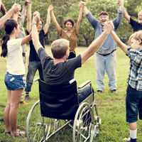 Person in a wheelchair joing a circle of people holding hands