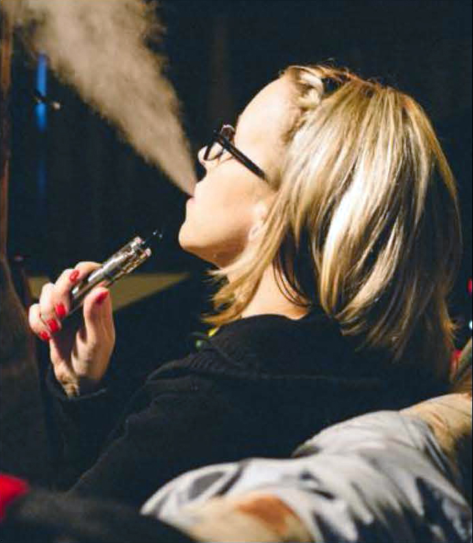 young women using an e-cigarette or vaping