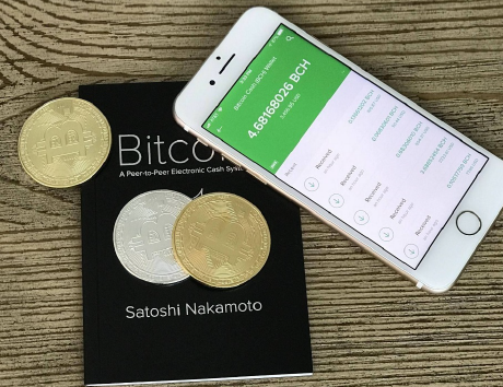 Photo of a mobile phone with a Bitcoin Cash wallet, Bitcoin whitepaper by Satoshi Nakamoto and Bitcoin.com pen.